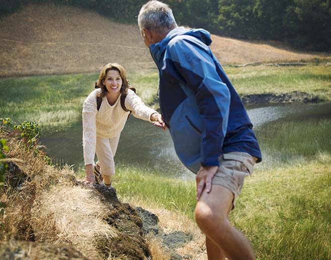 Older adults hiking near a lakeside trail